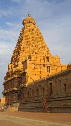 an ornate building with steps leading up to it and people walking around in the background