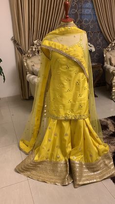 Pakistani indian designer dress Embroidered Kurta Set Evening Party Dress Bridesmaid Gift Minimalist Dress, Bohemian Simple Wedding Dress  About This Item Introducing the Mayon Bride from United Kingdom, a stunning addition to any bridal collection. This beautiful ensemble features a lemon yellow silk sharara set with intricate mirror and gotta work embellishments, adding an elegant touch to any special occasion. High-quality silk material Mirror and gotta work embroidery Comfortable and stylish sharara set The Mayon Bride exudes grace and sophistication. The lemon yellow color adds a pop of vibrancy to your wardrobe, while the mirror and gotta work embroidery provide an eye-catching detail that is sure to turn heads. This ensemble is made with high-quality silk material that feels soft ag Raw Silk Dress With Gota Work For Wedding, Raw Silk Wedding Dress With Gota Work, Wedding Dresses In Raw Silk With Gota Work, Gold Designer Dress For Navratri, Raw Silk Dress With Zari Work For Navratri, Yellow Zari Work Palazzo Set For Wedding, Yellow Palazzo Set With Zari Work For Wedding, Semi-stitched Resham Embroidered Gown For Diwali, Semi-stitched Raw Silk Dress With Gota Work