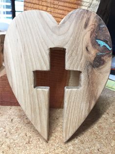 a wooden heart with a cross cut out of it