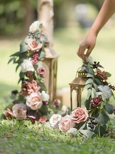 a person placing flowers on the ground next to a lantern