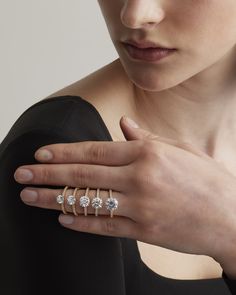 a woman's hand with three diamond rings on her left and the other hand holding an engagement ring