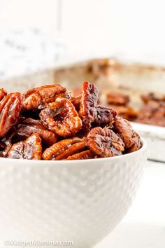 a white bowl filled with pecans sitting on top of a table