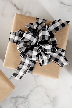 a present wrapped in brown paper with a black and white checkered bow on it