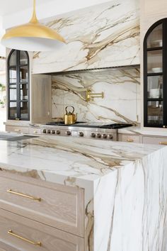 a kitchen with marble counter tops and gold accents