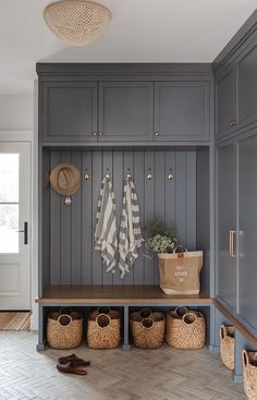 a mud room with gray cabinets and baskets