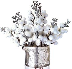 a silver vase filled with white flowers on top of a table