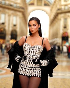 a woman in a black and white dress is posing for the camera