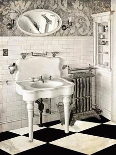 an old fashioned bathroom with black and white checkerboard flooring, antique sink and mirror