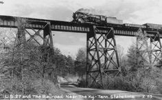 an old photo of a train crossing a bridge with trees on both sides and the words, railroad near by