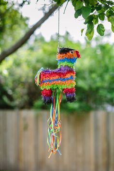 a colorful pinata hanging from a tree