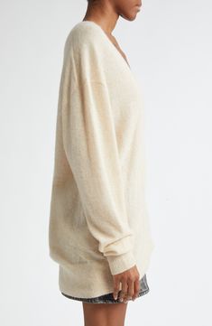 A fine blend of silk, alpaca and cashmere softens this oversized sweater knit with dramatically dropped shoulders and a deep V-neck. Deep V-neck Long sleeves Dropped shoulders Ribbed cuffs and hem 37% silk, 32% baby alpaca, 31% cashmere Dry clean Imported Designer Clothing Cream Cashmere V-neck Sweater, Cream Oversized V-neck Sweater, Oversized Fine Knit V-neck Sweater For Fall, Cashmere V-neck Soft Knit Sweater, V-neck Cashmere Sweater For Loungewear, Oversized Fine Knit V-neck Sweater, Oversized V-neck Fine Knit Sweater, Elegant Oversized V-neck Sweater, Cozy Mohair V-neck Sweater