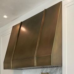 a kitchen with an oven and range hood in the middle of the wall above it