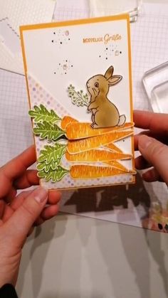 someone is holding up a card that has carrots on it and a bunny in the center