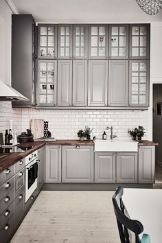 a kitchen with gray cabinets and wooden floors