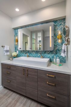 a bathroom with a large mirror above the sink and wooden cabinetry on the wall