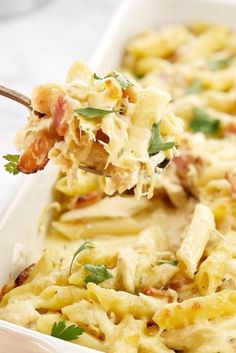 a close up of a spoonful of food in a casserole dish with meat and cheese