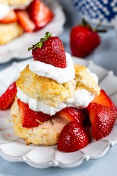 strawberry shortcakes stacked on top of each other with whipped cream and strawberries