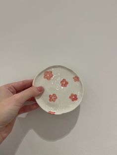 a hand holding a small bowl with flowers on it