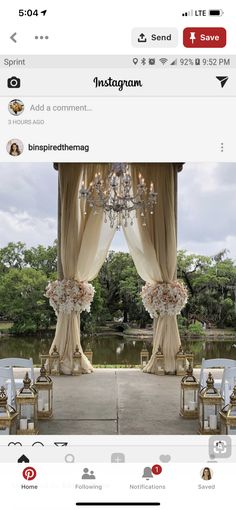 an outdoor wedding ceremony setup with chandelier and flowers on the aisle, overlooking a pond