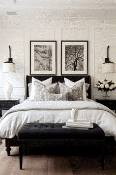 a bed with white sheets and pillows in a bedroom next to two pictures on the wall