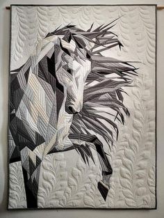 a black and white quilt with a horse on it's back, next to a wall hanging