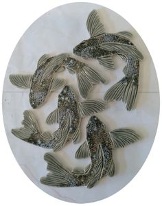 four fish are shown in the middle of a circular pattern on a white marble surface