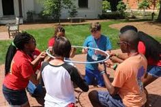 a group of kids playing with a hula hoop on a brick walkway in front of a house