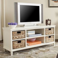 a flat screen tv sitting on top of a wooden entertainment center in a living room