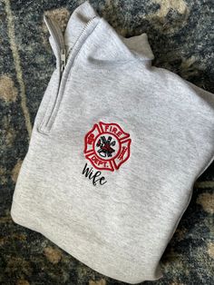 a firefighter's sweatshirt with the word wife printed on it and a red fire hydrant in the center