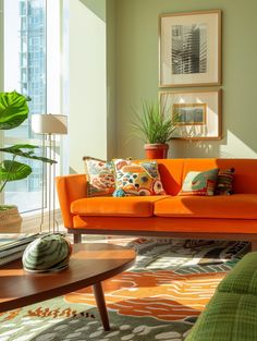 a living room with an orange couch and green plants in the corner, on top of a multicolored rug