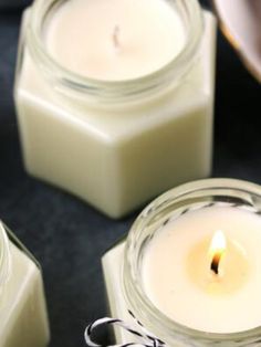 three candles sitting next to each other on top of a black tableclothed surface