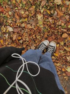 a person with their feet up on the ground in front of some leaves and grass