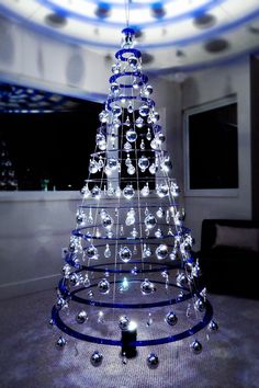 a lighted christmas tree in the middle of a living room with blue lights on it