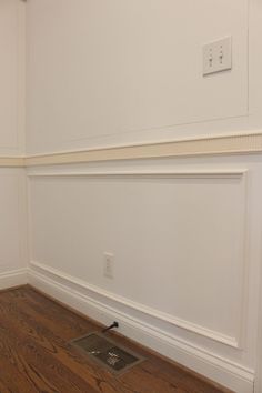 an empty room with hard wood floors and white walls