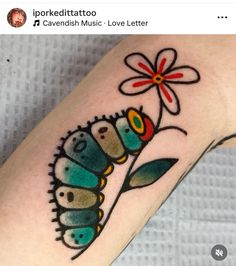 a tattoo design on the arm of a ladybug with flowers and leaves painted on it