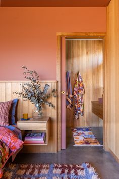 a bedroom with pink walls and wooden paneling on the wall, along with a bed