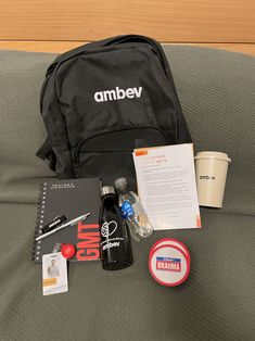 the contents of an ambev bag laid out on a bed with coffee and other items