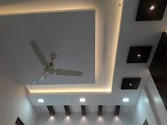 an empty room with white walls and ceiling lights on the ceiling is lit by recessed lighting