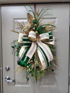 a green and white christmas wreath hanging on a door