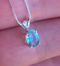 "Beautiful, dainty/minimalist, but will definitely not gone unnoticed, natural, paraiba, and paraiba color: known for its bright neon colours. The colour ranges from blue to green. Stone size: 7*5mm, 0.90 carats, set in 925 sterling silver, with 18\" inches long sterling silver box chain." Blue Round Pendant Jewelry For May Birthstone, Blue Round Pendant For May Birthstone, Blue Pendant Jewelry For May Birthstone, Round Turquoise Aquamarine Necklace, Turquoise Aquamarine Round Necklace, Dainty Blue Aquamarine Jewelry, Turquoise Aquamarine Necklace, Everyday Blue Topaz Jewelry, Green Blue Topaz Jewelry Gift