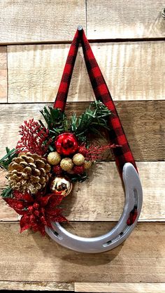 a christmas wreath hanging on the side of a wooden wall with ornaments and pine cones