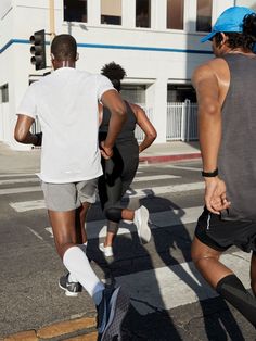 two men are running down the street with their feet in the air and one man is holding onto his leg