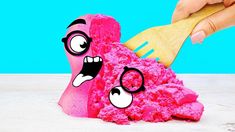 a hand holding a brush over pink sponge with eyes and mouth drawn on the side