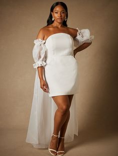 a woman in a white dress posing for the camera with her hands on her hips