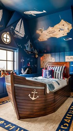 a child's bedroom decorated in blue and white with a wooden boat bed frame