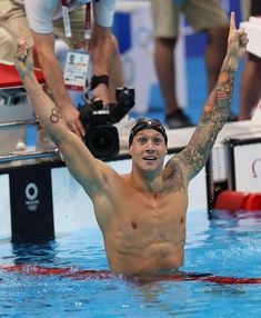 a man swimming in a pool with his hands up