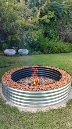 an outdoor fire pit in the middle of some grass