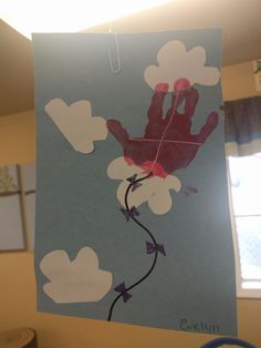 a handprint on a piece of paper that is hanging from a string in front of a window