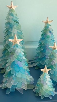 three plastic christmas trees with starfish on them