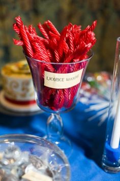 there is a small glass vase with red candles in it on the table next to other items